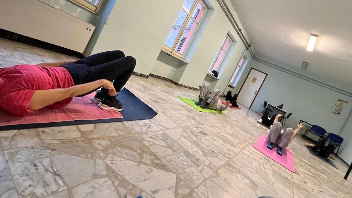 Lezione di gruppo di Coach Fitness Girl: esercizi a terra sui tappetini